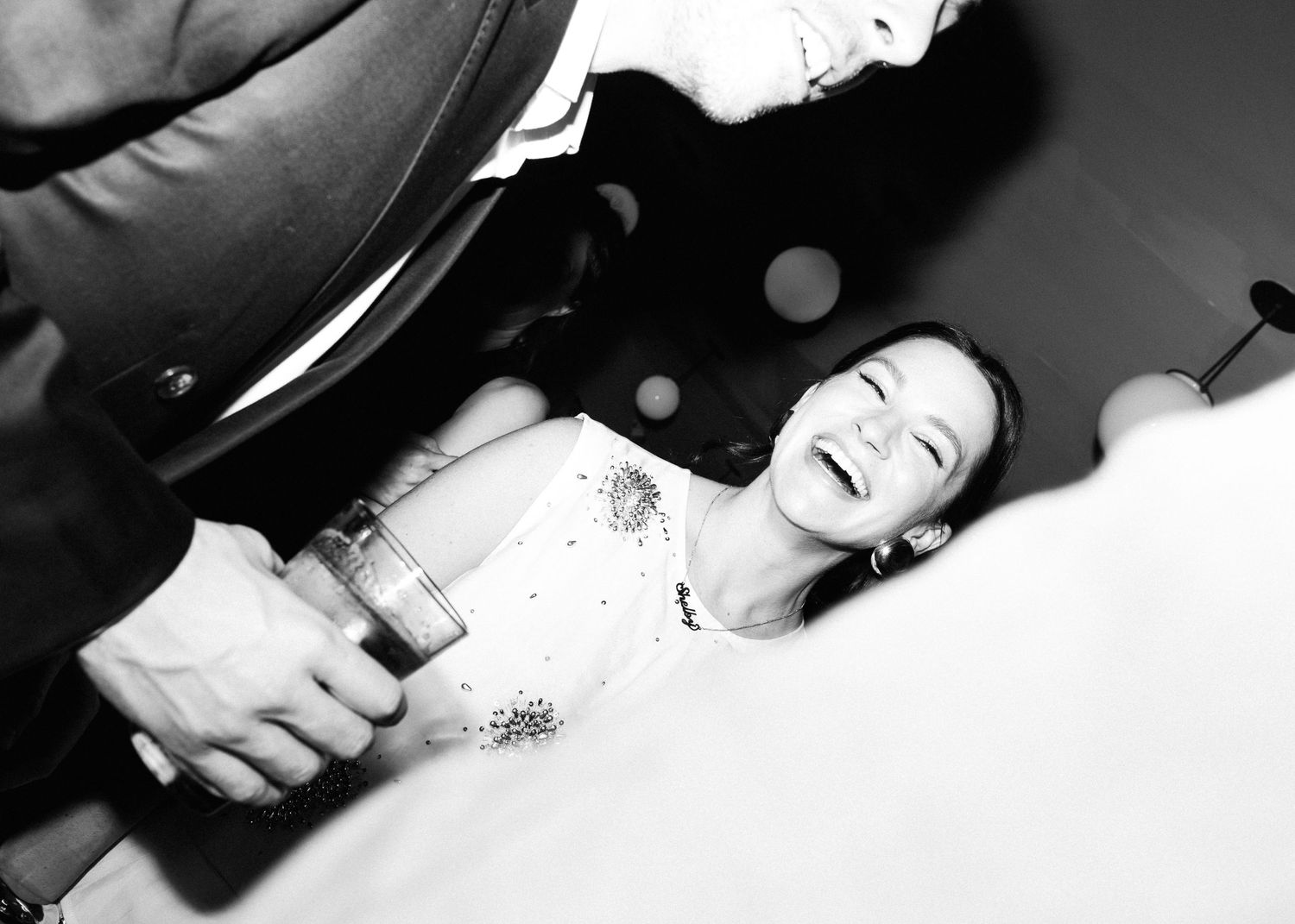 A candid black and white photograph capturing a moment of pure joy and laughter.
