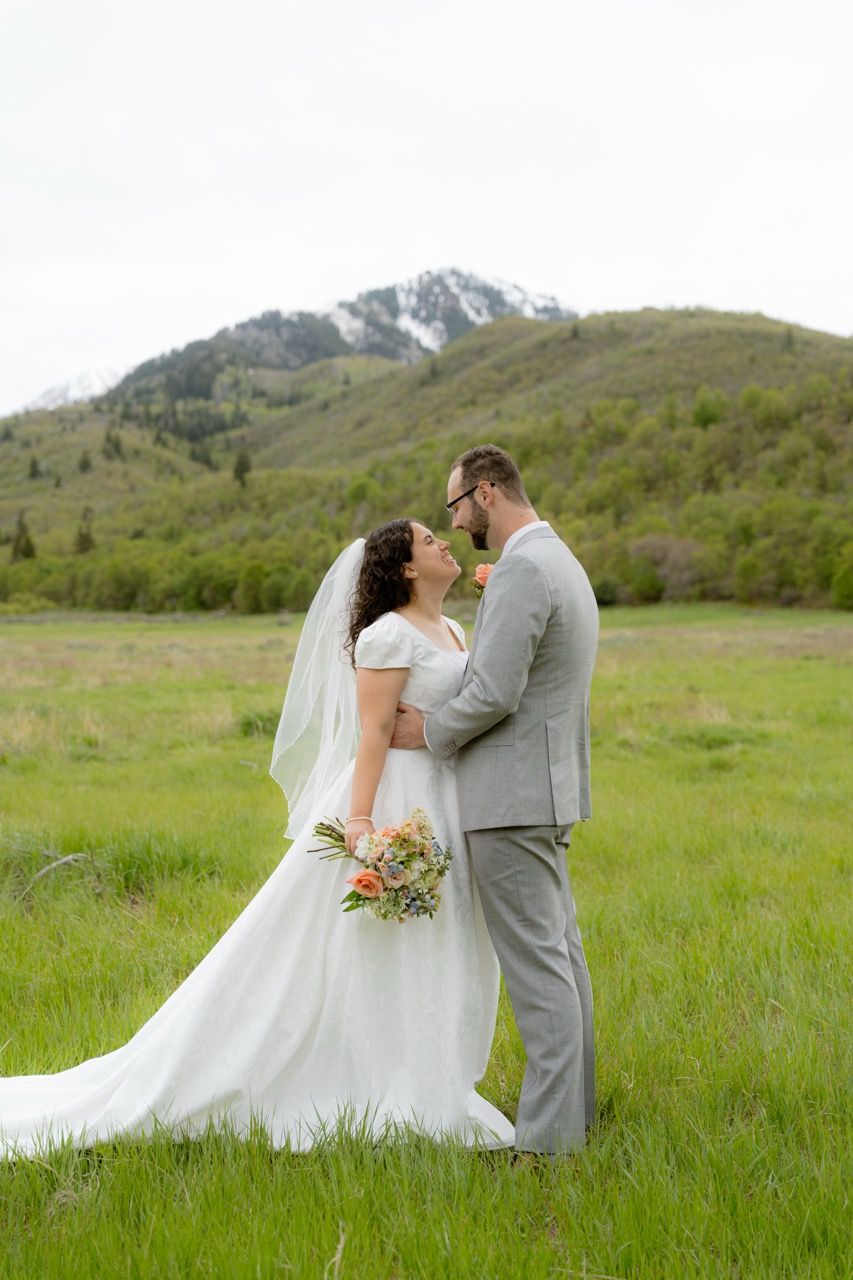 Bride and groom in Utah wedding photographed by Jensen Photo & Film. Mountain wedding backdrop