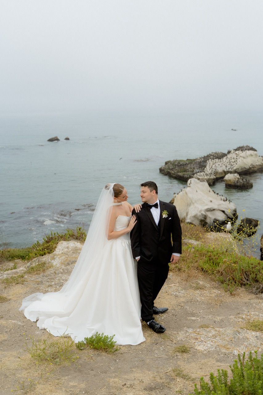 Bride and groom on cliffside California coast wedding