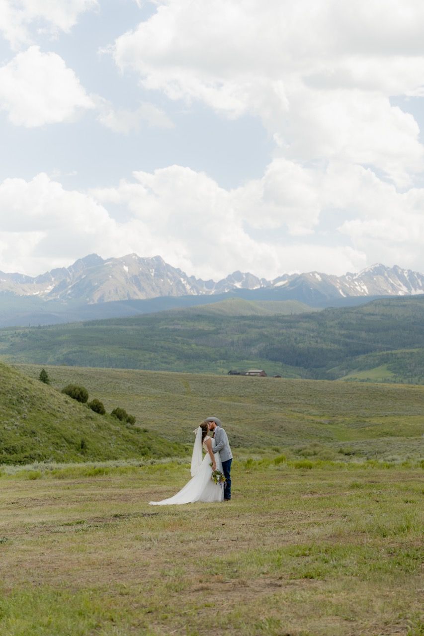 Bride and groom in Colorado wedding photographed by Jensen Photo & Film. Mountain wedding backdrop
