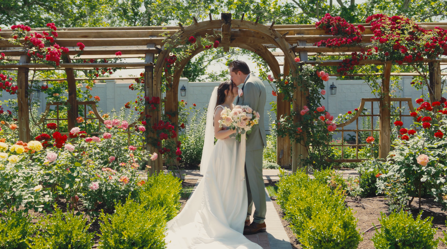 Bride and groom at Thanksgiving Point Rose Garden in Utah surrounded flowers. Videography by Jensen Photo & Film