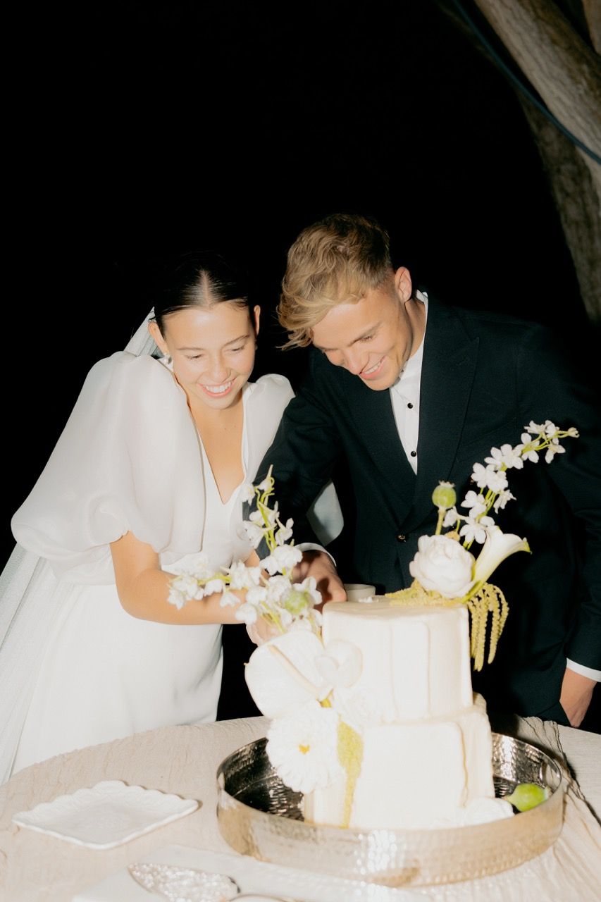 Bride and groom in Utah wedding photographed by Jensen Photo & Film. Flash wedding cake cutting photography.