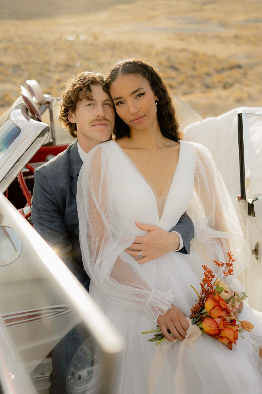 Bride and groom in desert Utah wedding photographed by Jensen Photo & Film. Wedding getaway car photography.