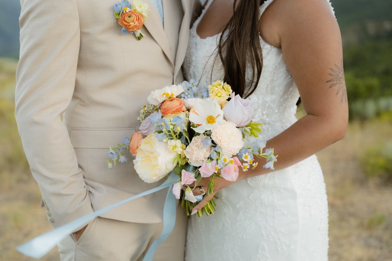 Bride and groom holding wedding bouquet in Park City, Utah wedding photographed by Jensen Photo & Film