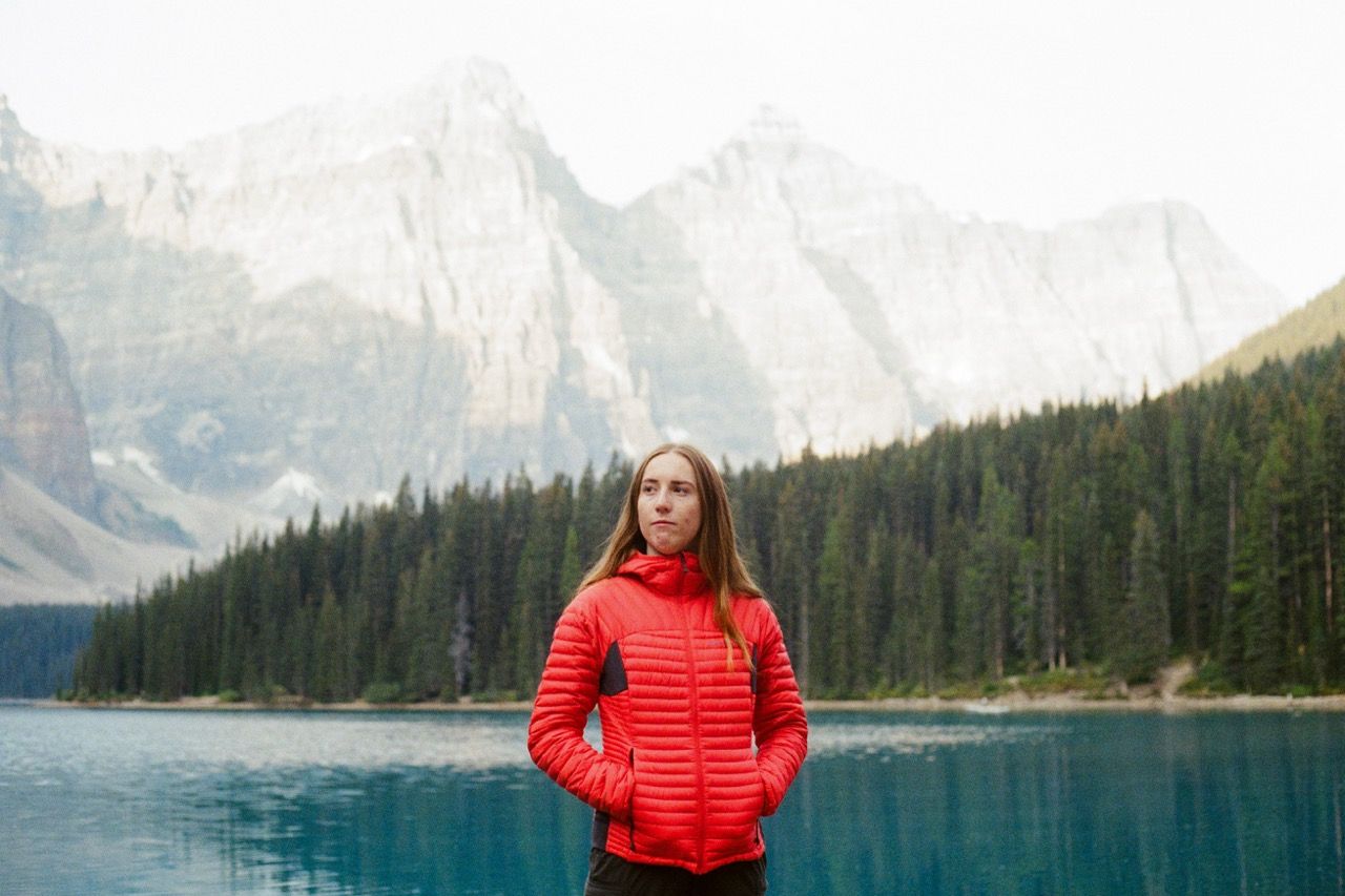 Turquoise glacial lake surrounded by snow-capped mountains and evergreen forest in Banff National Park.