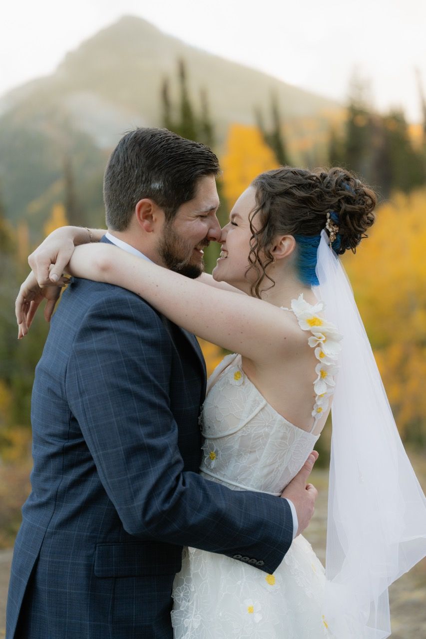 Bride and groom in fall Utah wedding photographed by Jensen Photo & Film. Mountain wedding backdrop
