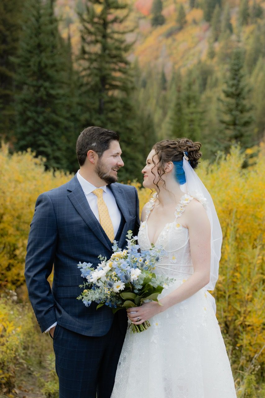 Bride and groom in fall Utah wedding photographed by Jensen Photo & Film. Mountain wedding backdrop