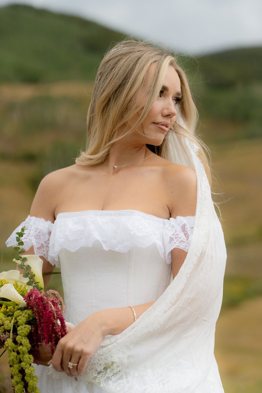 Bride with lace dress and veil holding chartreuse and plum wedding bridal bouquet