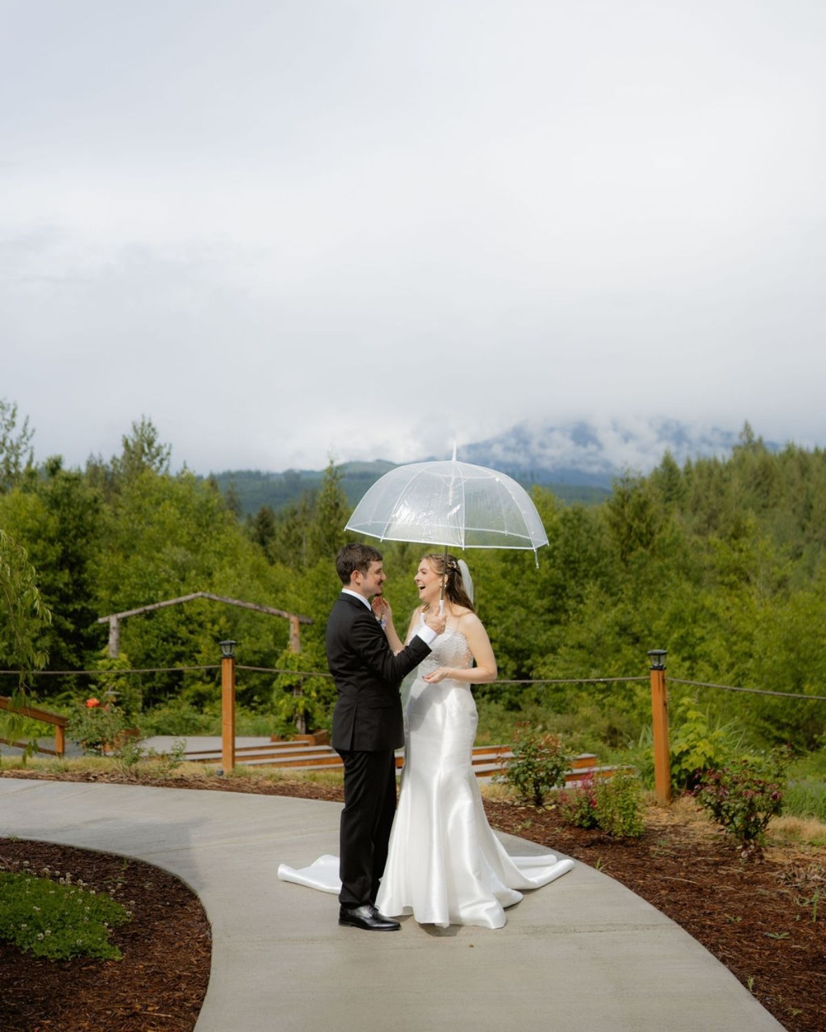 Wedding couple holding umbrella during rainy Washington wedding