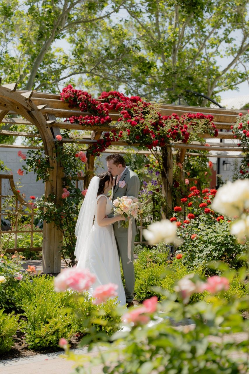 Bride and groom in Utah wedding photographed by Jensen Photo & Film. Thanksgiving Point Rose Garden floral wedding.