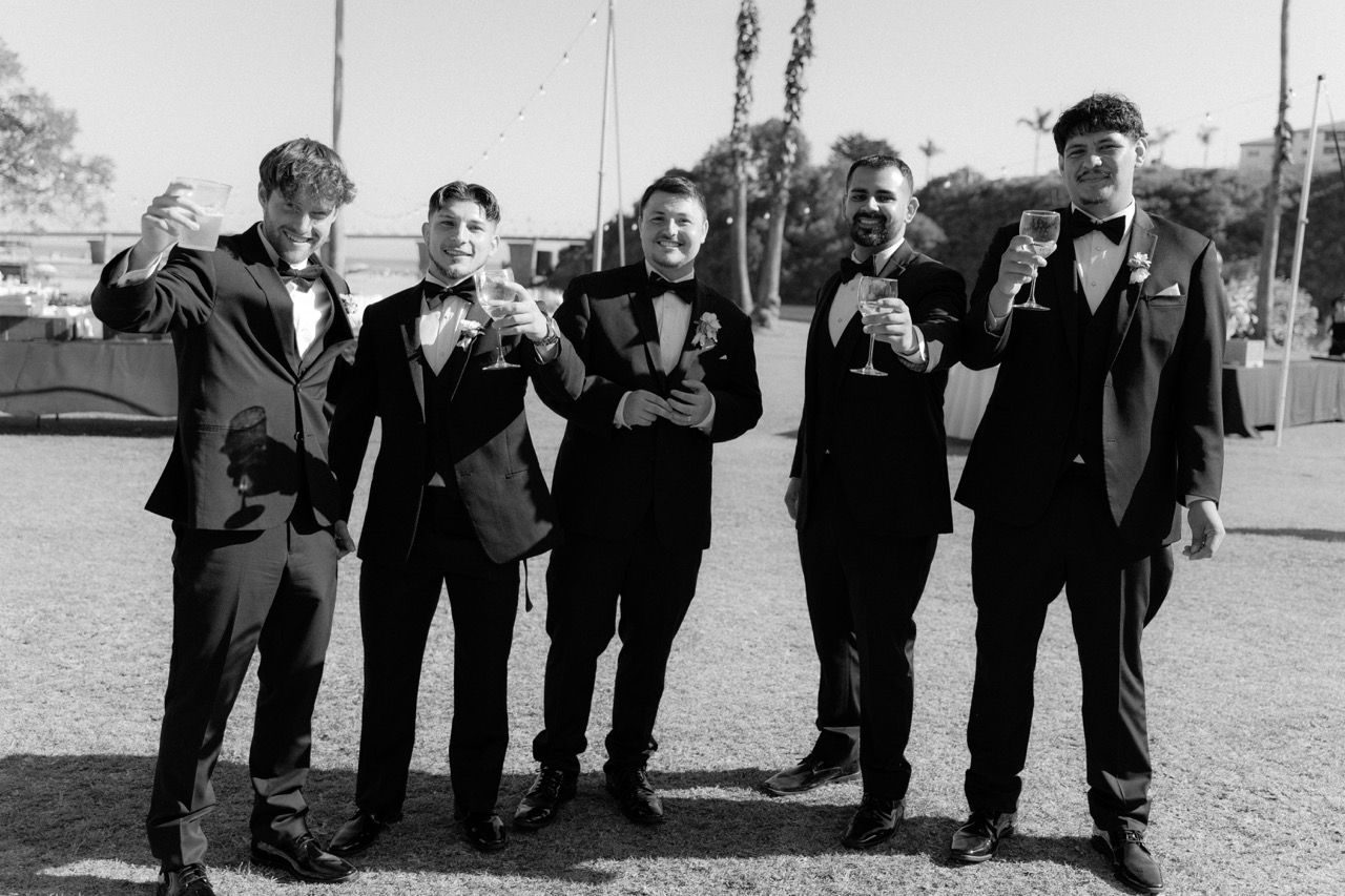 Groom and groomsmen candid photo doing a cheers with champagne