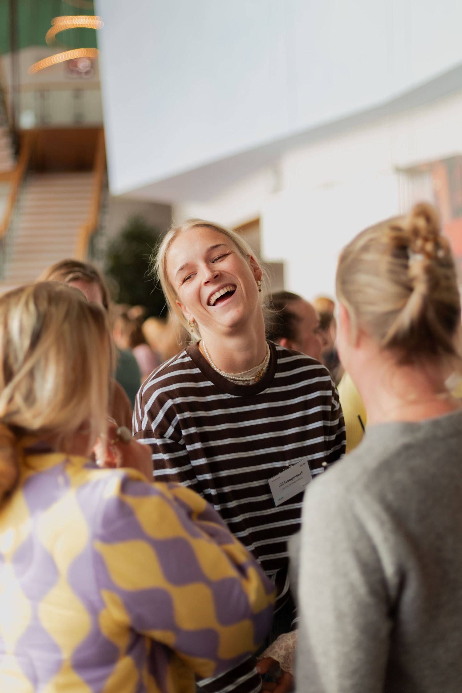 A group of people share a joyful moment of laughter together in a bright indoor setting.