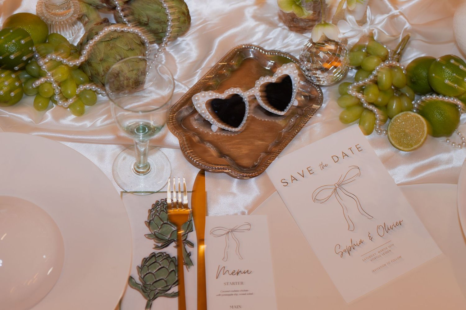 Wedding reception table setting with elegant place cards, greenery and decorative details.