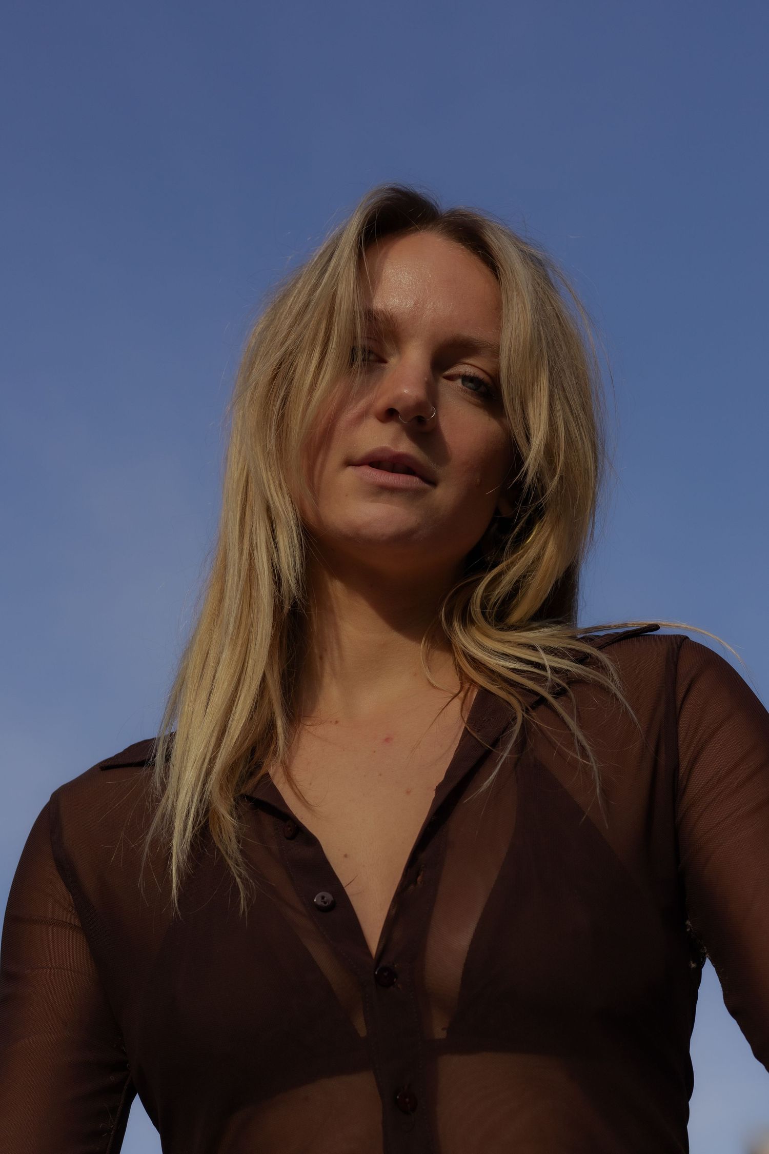 Outdoor portraits against blue sky with brown top and natural lighting.