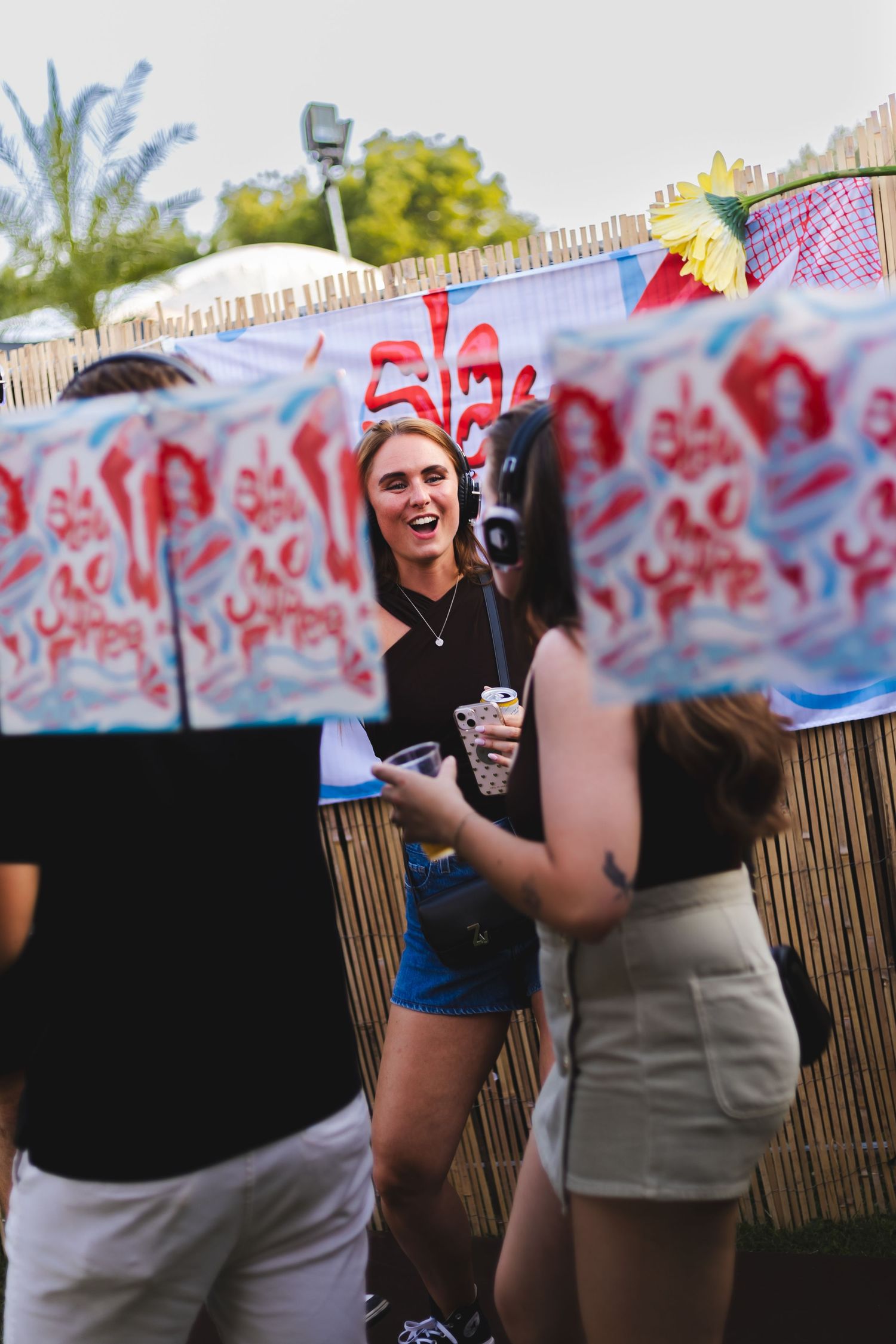 Group enjoying themselves at an outdoor party with decorative banners overhead.
