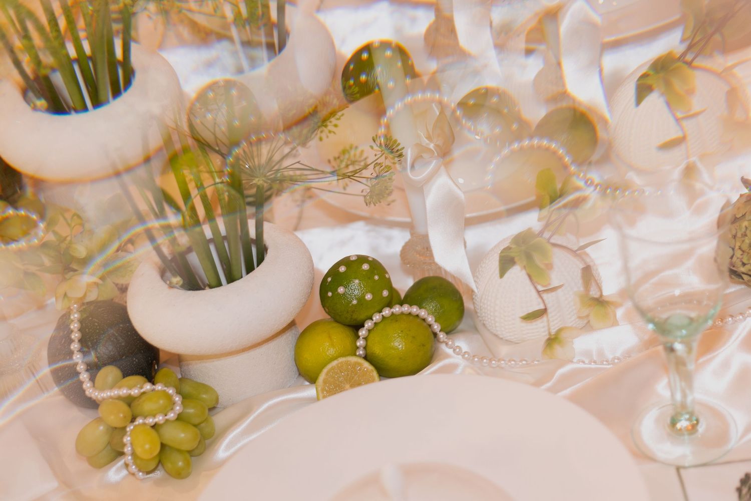 Elegant white wedding reception table setting with fresh flowers and place settings.