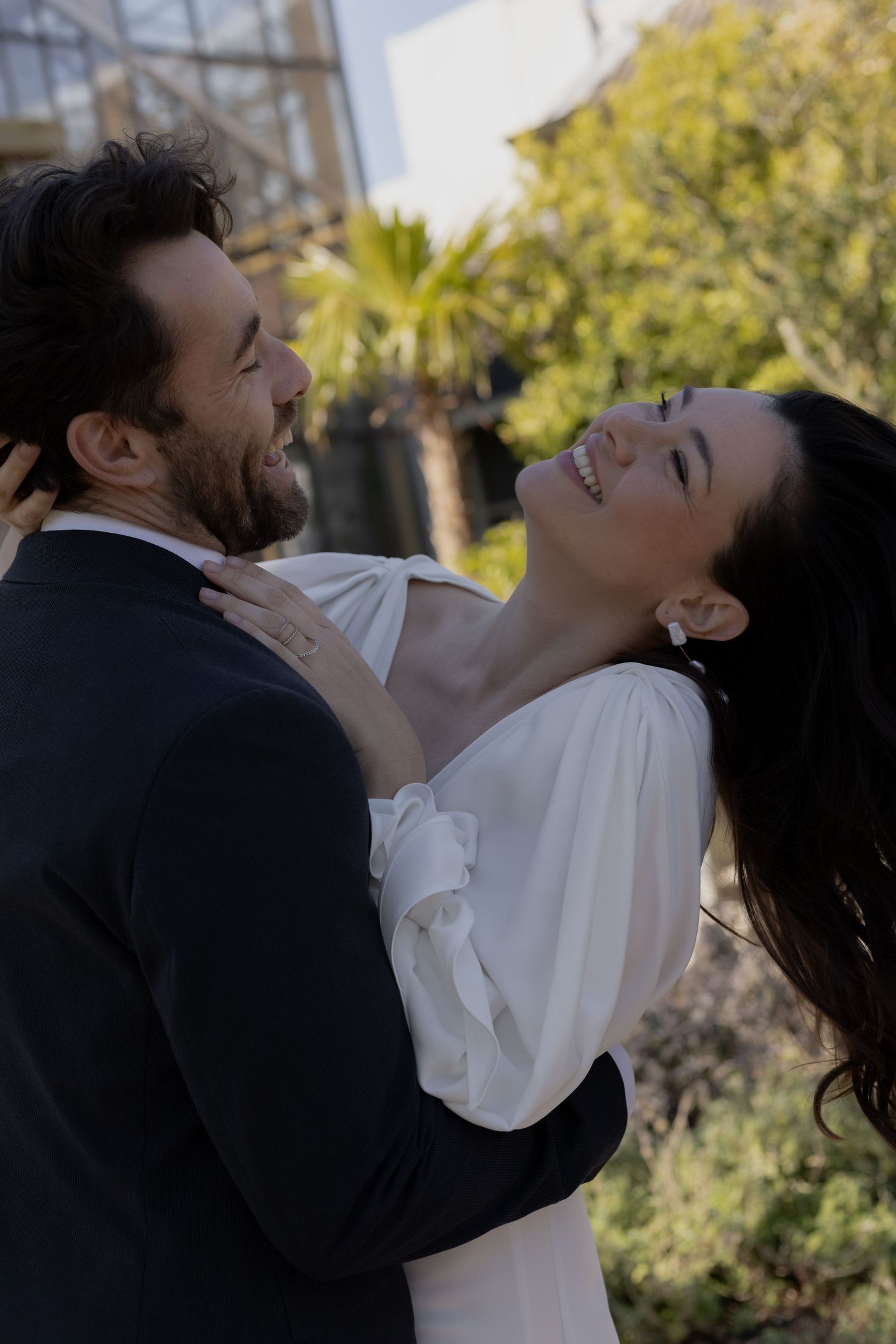 Romantic candid moments captured in a sunlit garden setting.