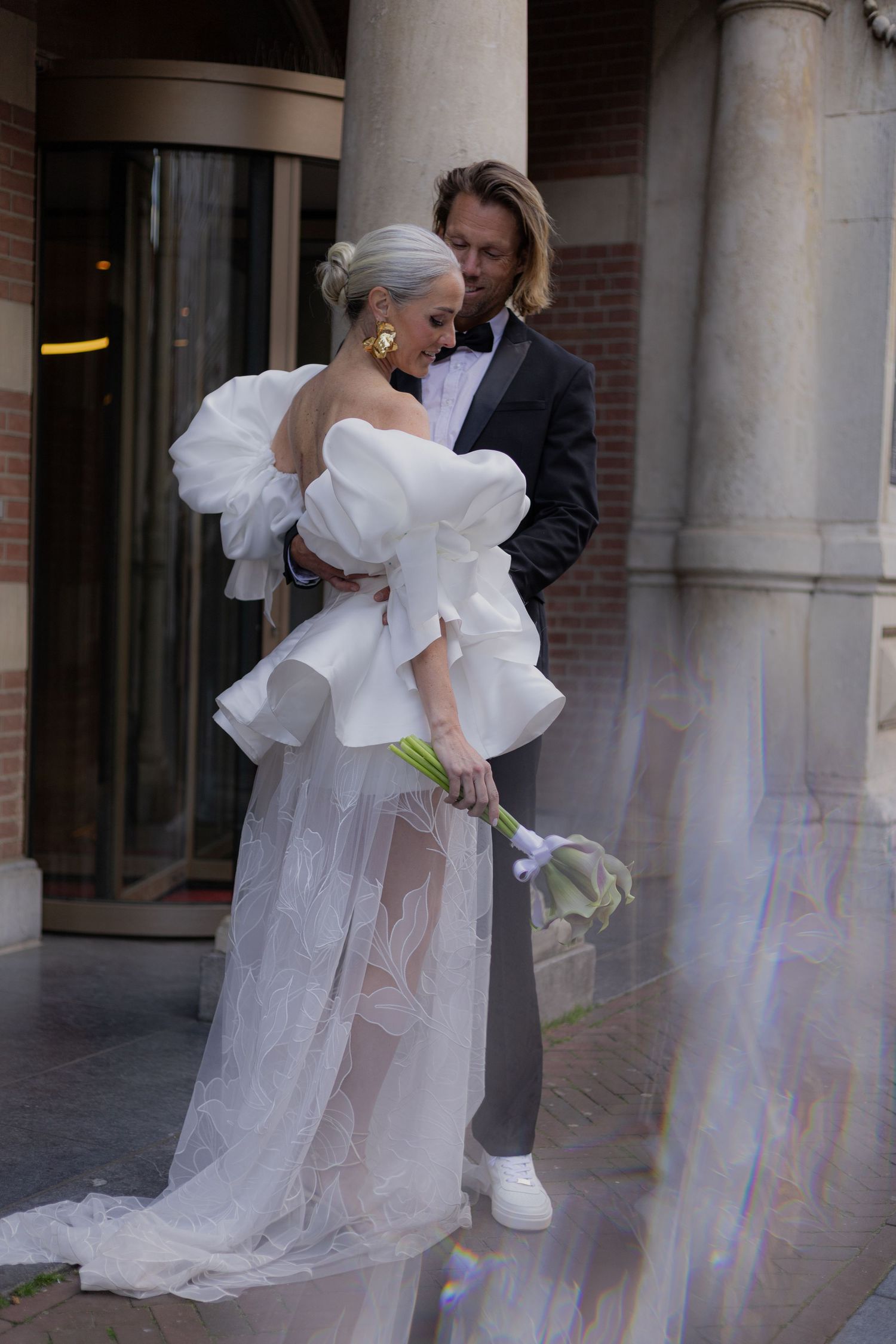 Architectural columns frame a romantic wedding scene with dramatic lighting effects.