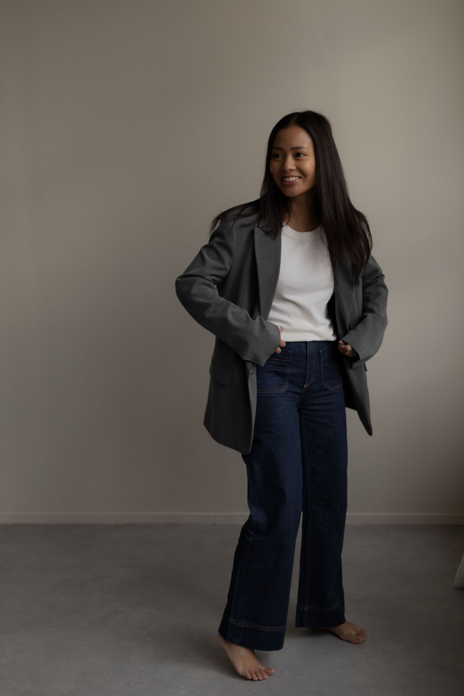 Fashion series showing casual business style with blazer and jeans in natural lighting.