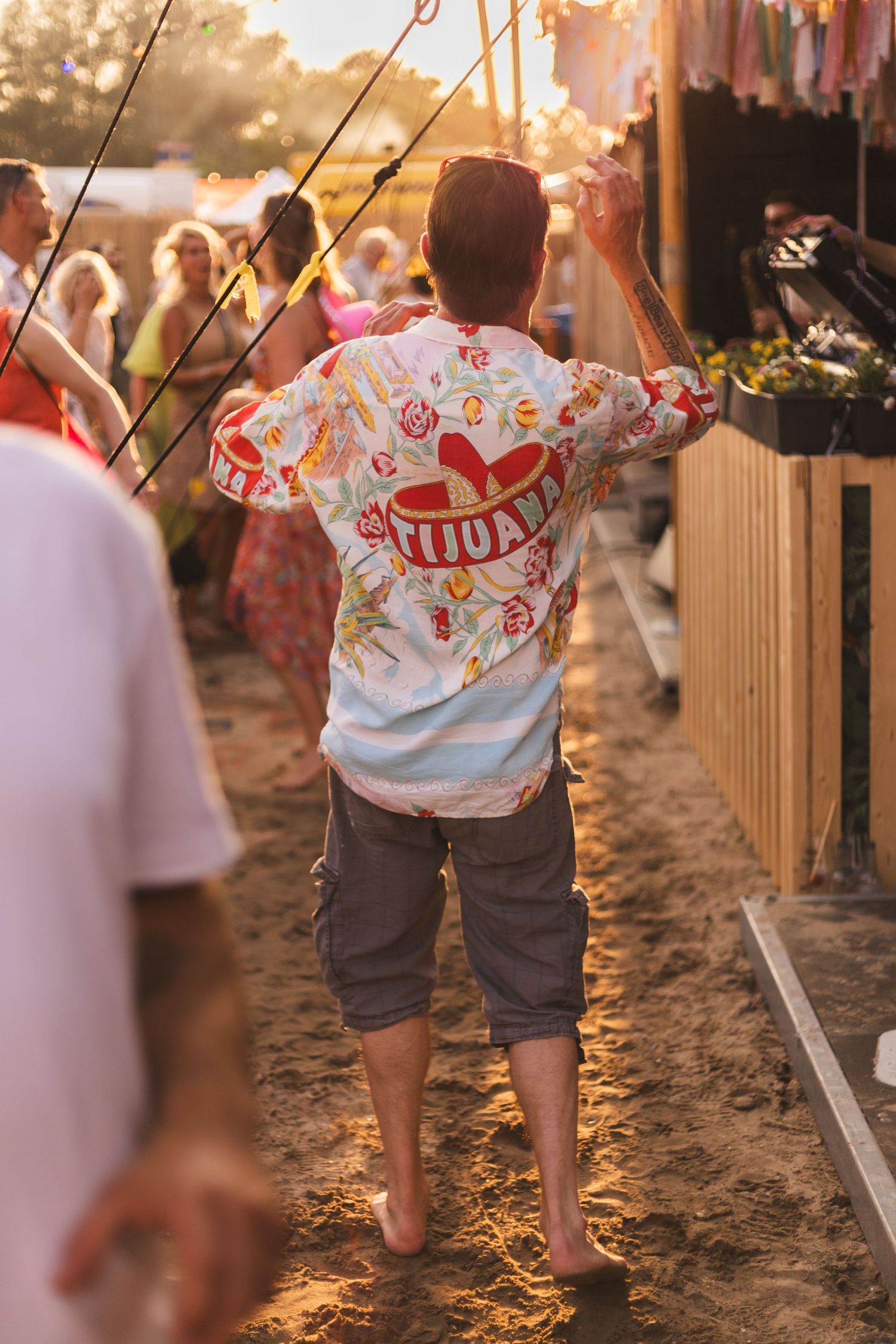 Children walking along a sandy path at sunset wearing festive t-shirts.