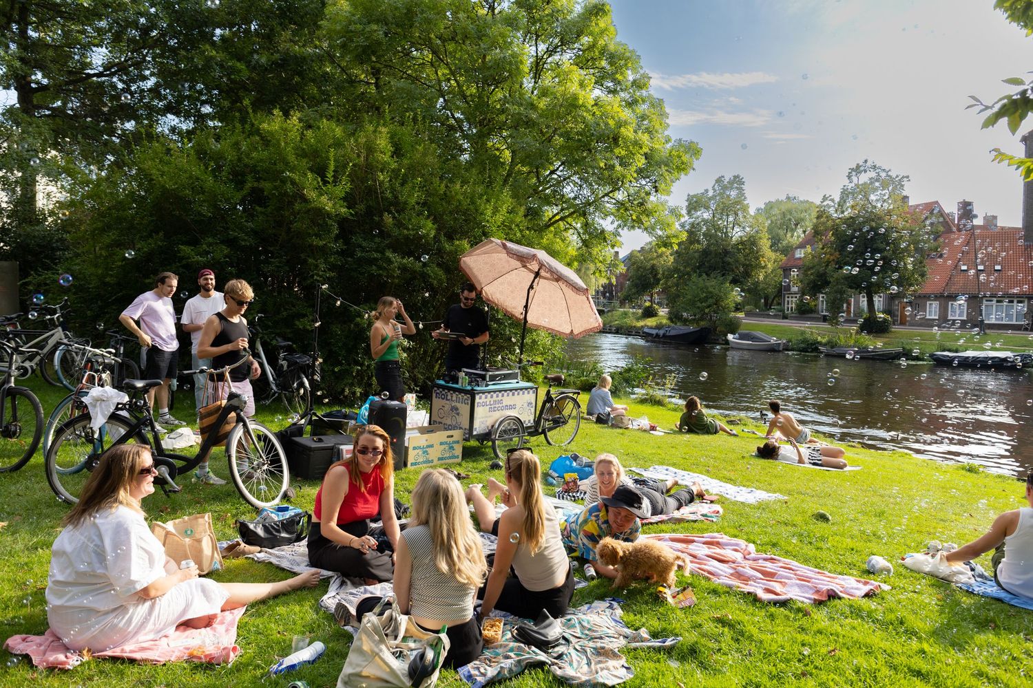 Panoramic view of people gathered on a grassy slope for an outdoor event.