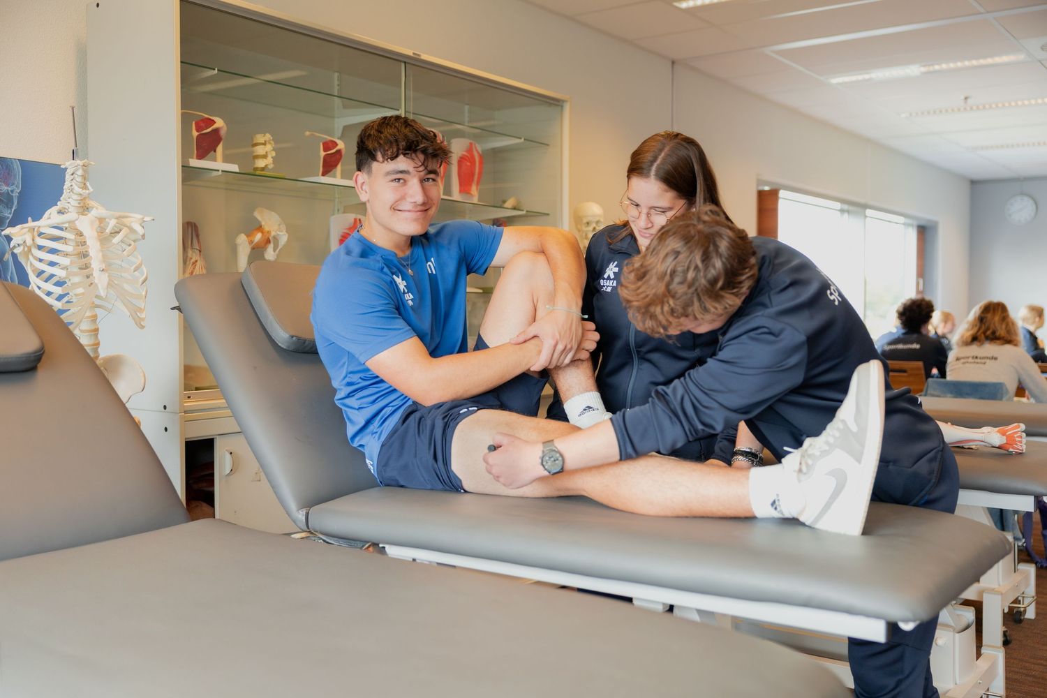 A student practices proper body mechanics and patient positioning techniques during healthcare training exercises.