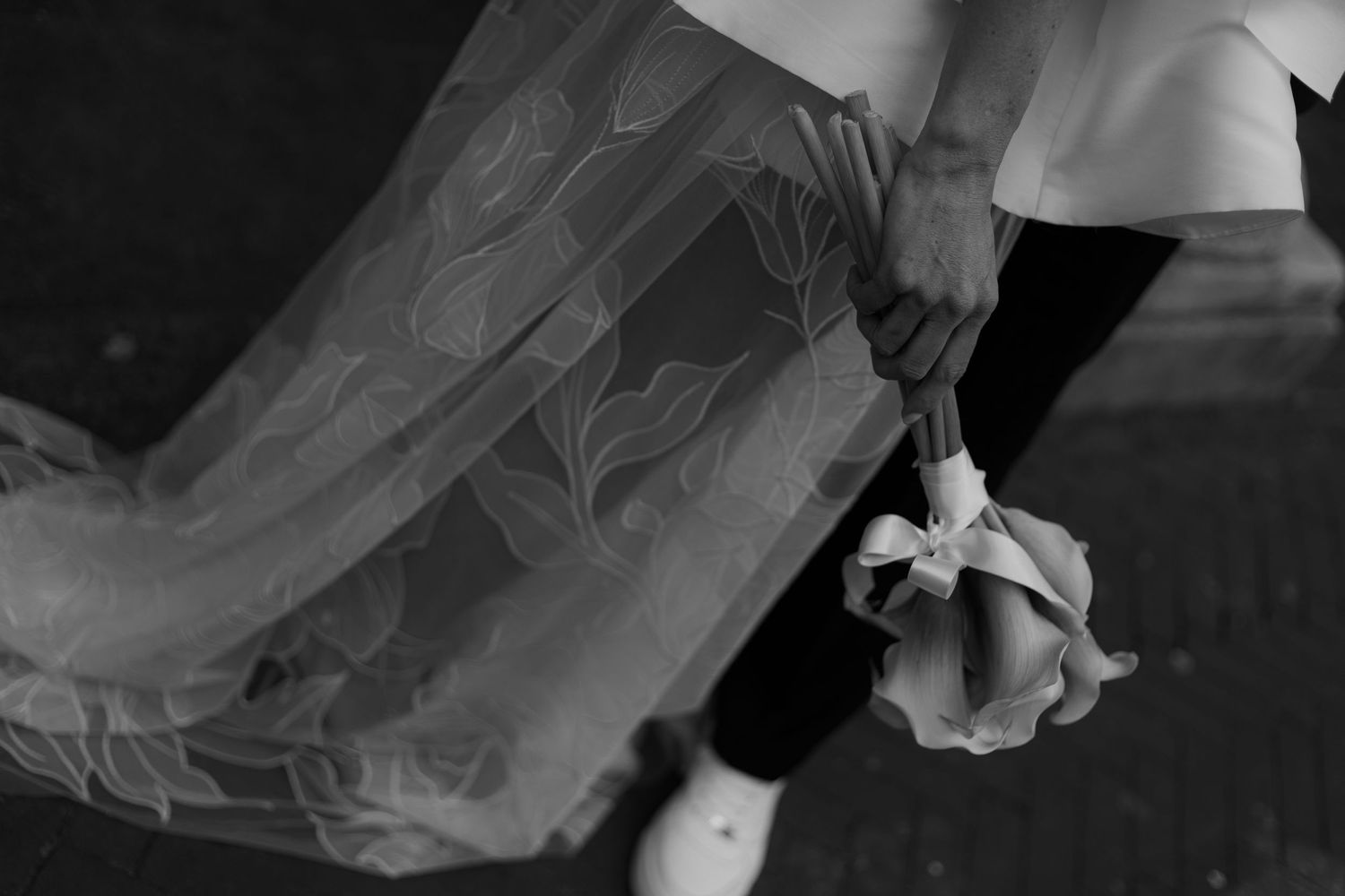 Close-up details of delicate white wedding dress fabric and lace.