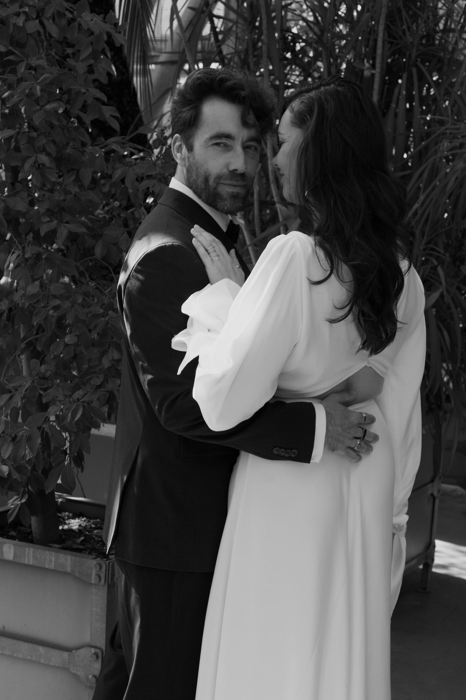 Black and white wedding photo showing an intimate moment between newlyweds.