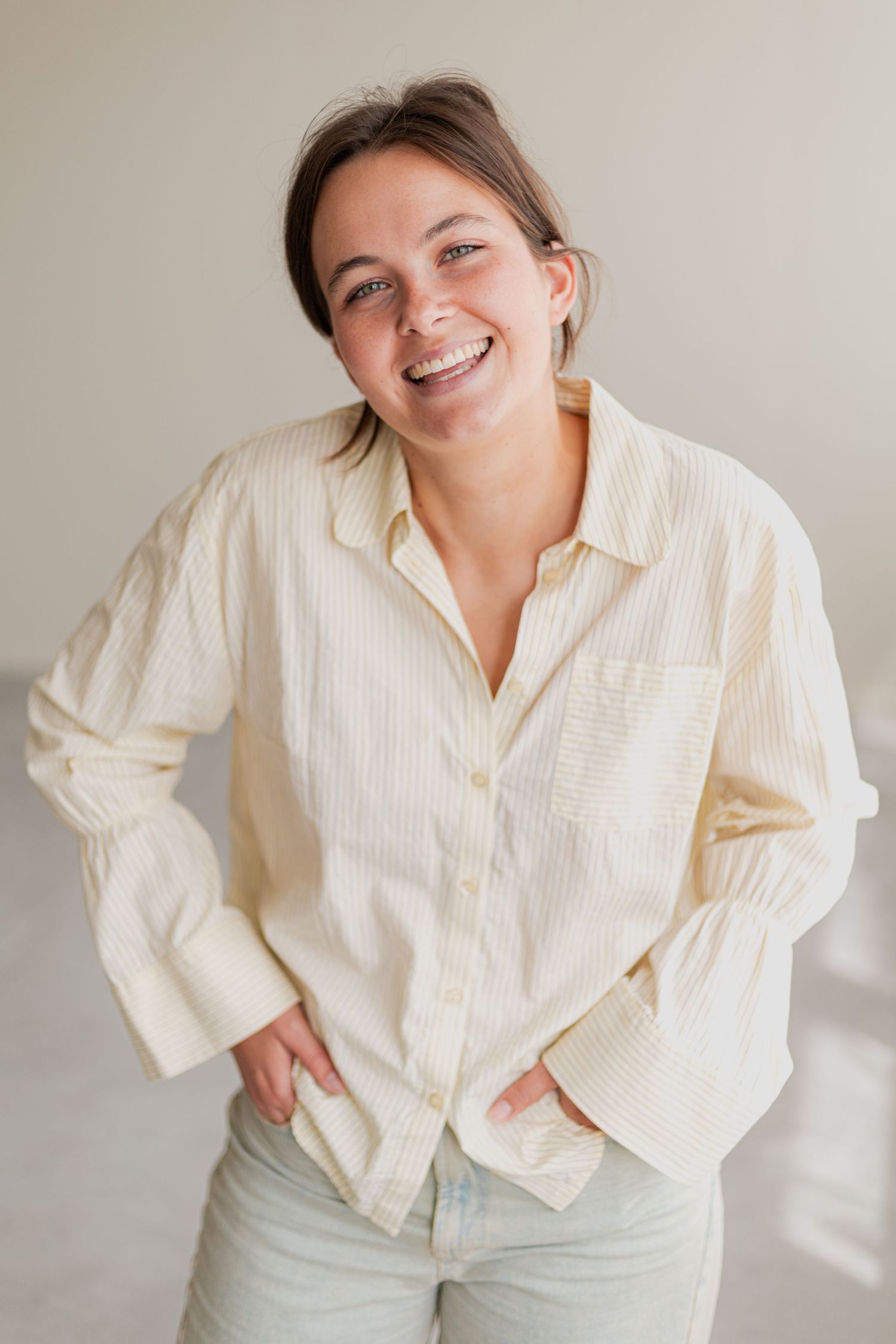 Casual portrait wearing an oversized cream button-down shirt with light denim.