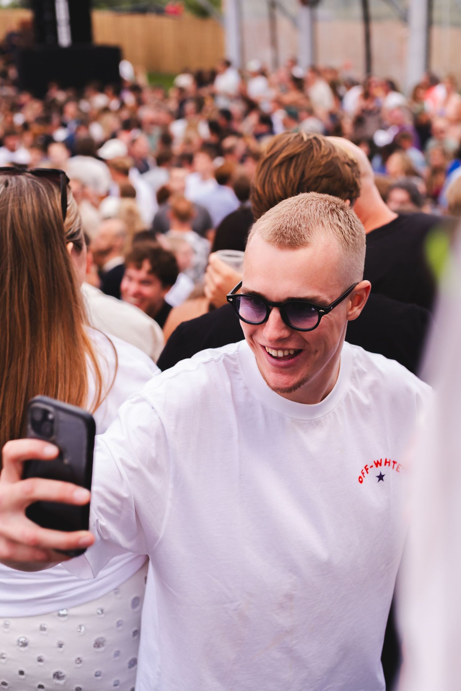 Festival attendees in white t-shirts enjoying outdoor summer event.