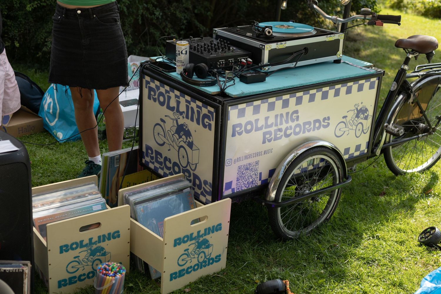 Rolling Records outdoor display with vintage-style signage and record boxes set up on tables.