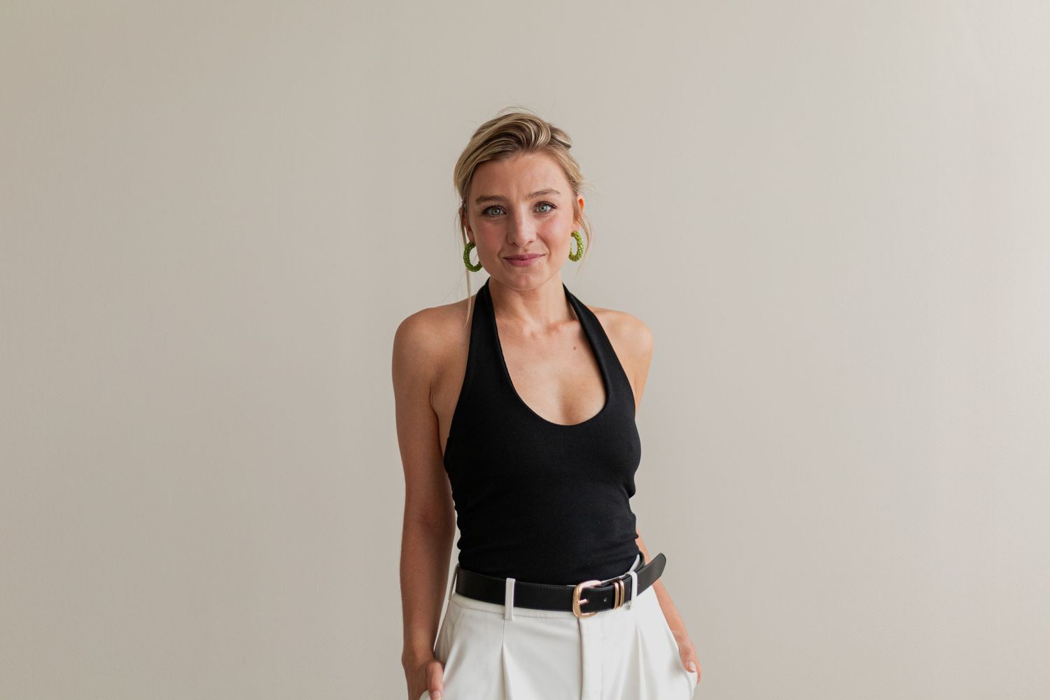 Fashion portraits featuring a person in a black tank top against a light colored wall.