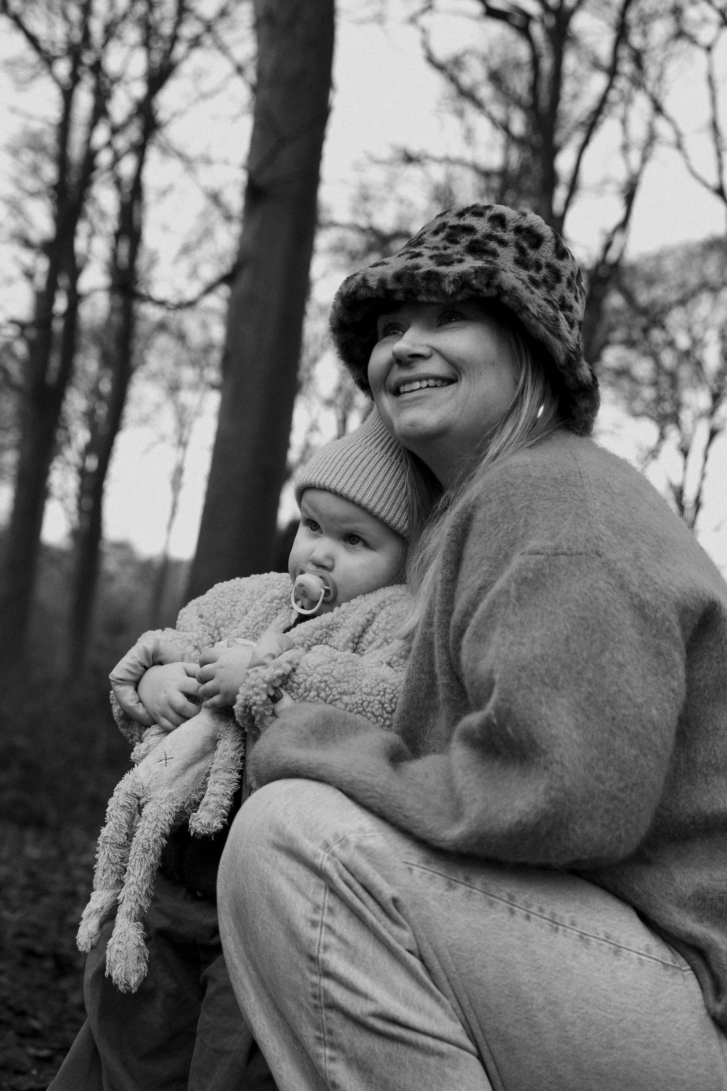 A black and white photo sequence shows a person in a sweater holding and playing with a stuffed animal toy.