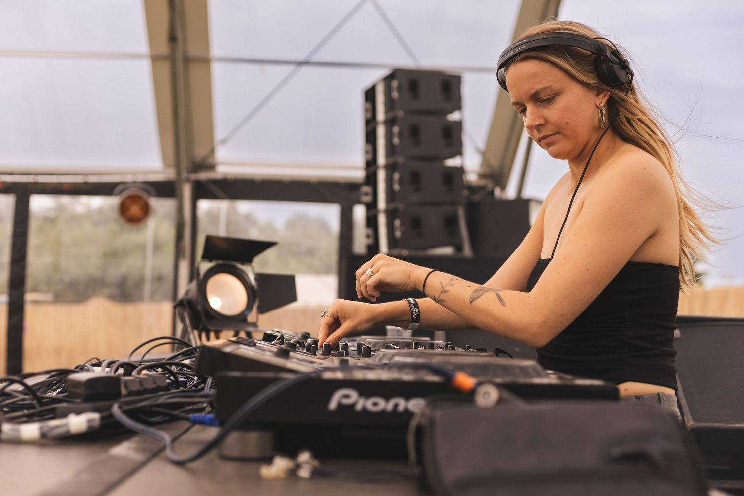 Music producer working on audio equipment at a professional mixing station.
