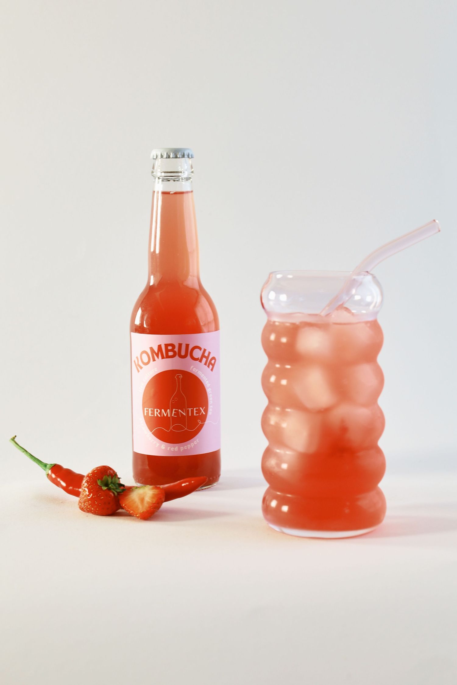 Pink kombucha bottles arranged in a minimalist product photography composition.