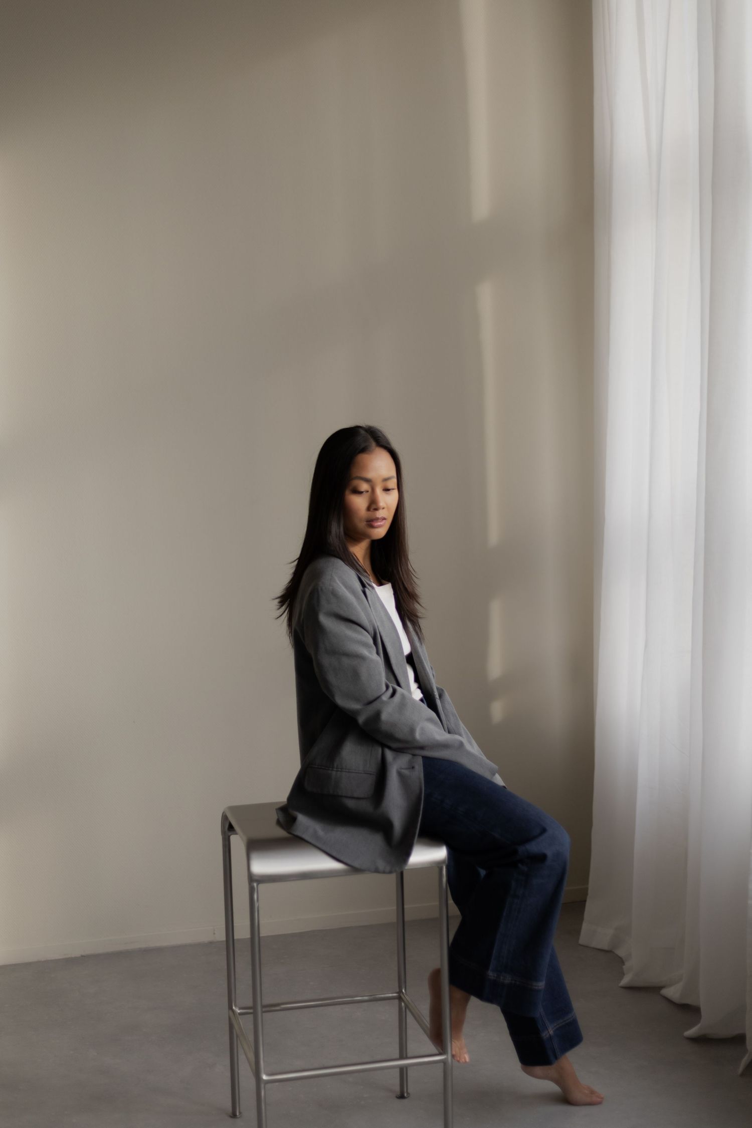 Minimalist studio portraits showing different seated poses on a simple chair.