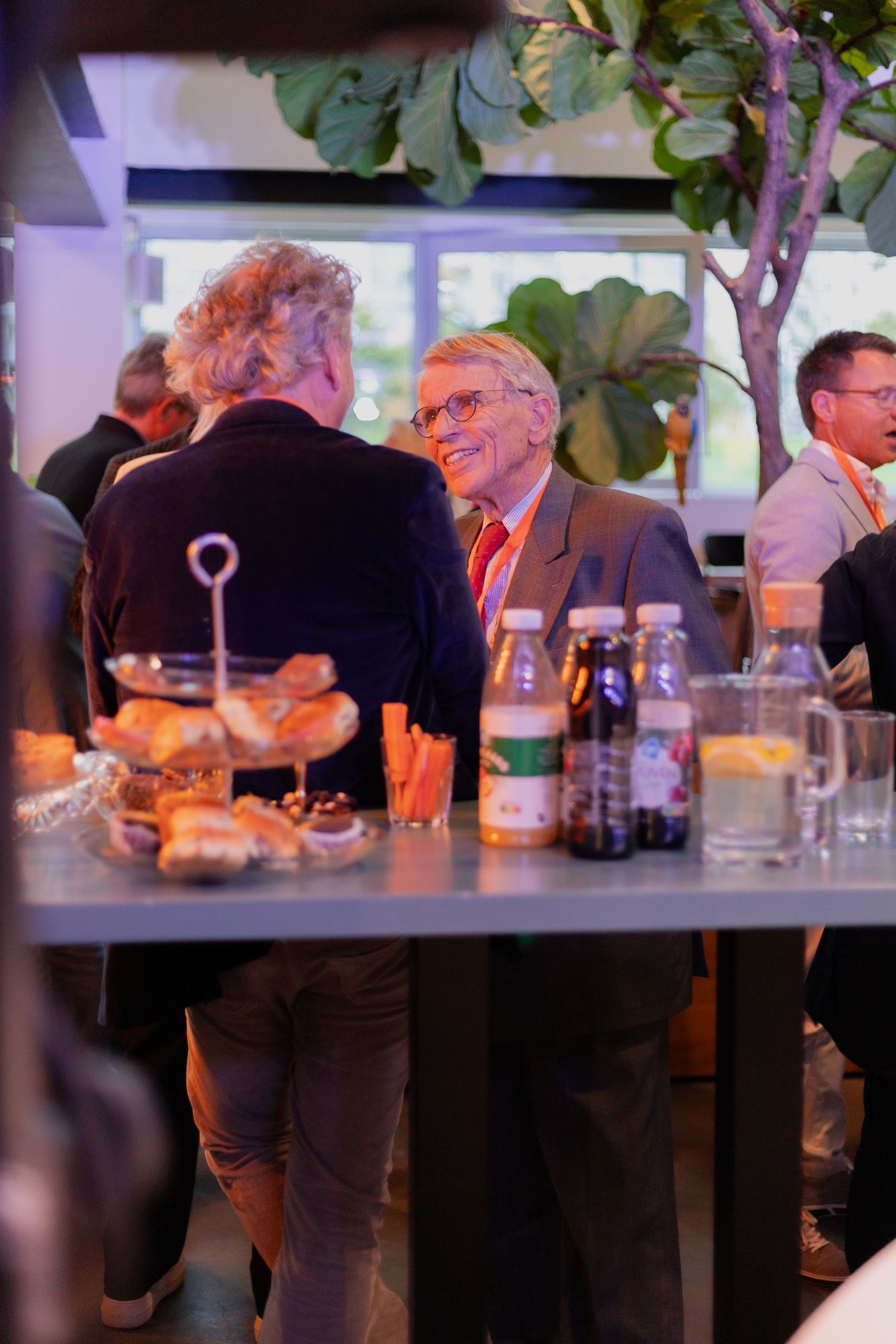 People gathered at a dimly lit bar or restaurant table for a social event.
