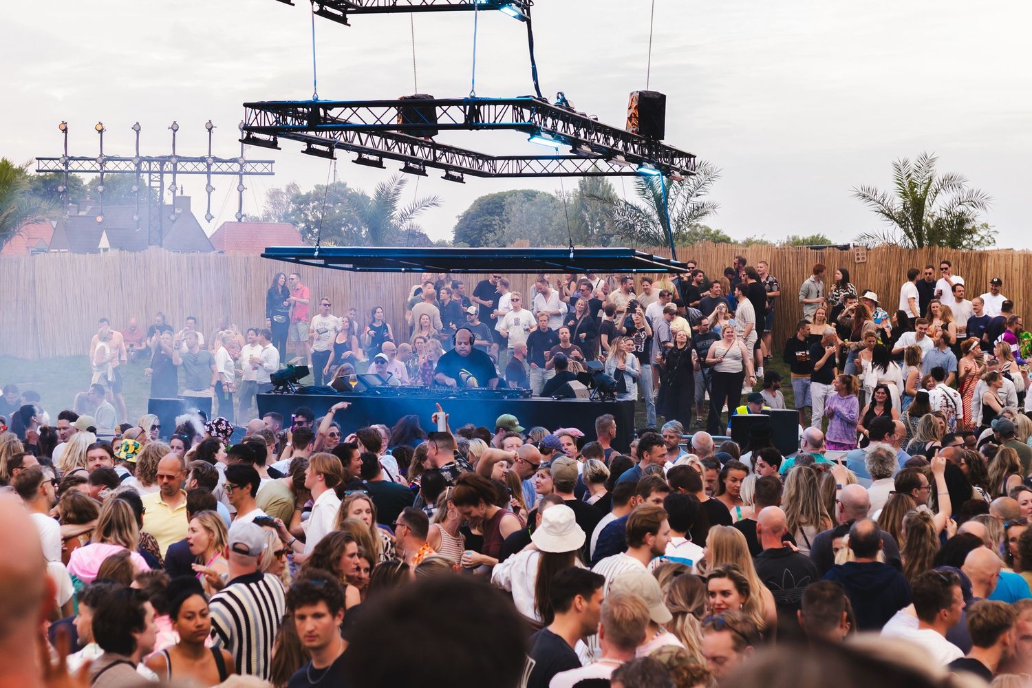Aerial view of massive outdoor festival crowd gathered in daylight.
