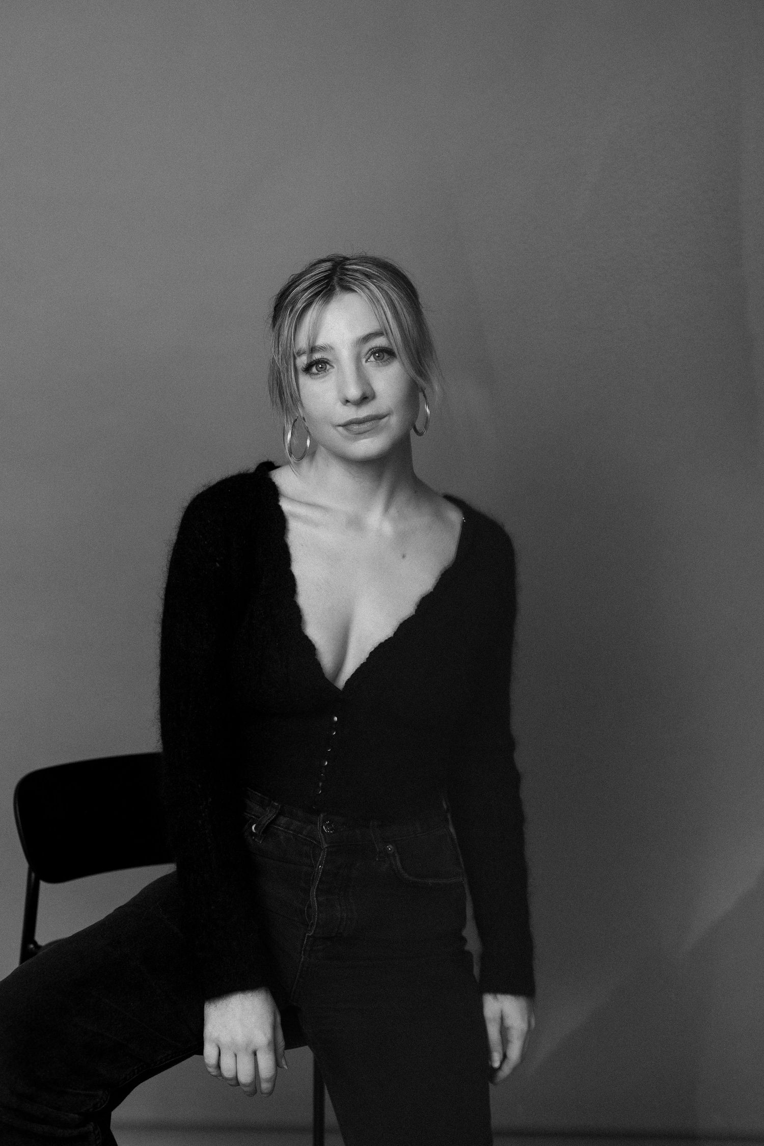 Black and white portrait series showing a woman in a dark top posing expressively against a plain background.