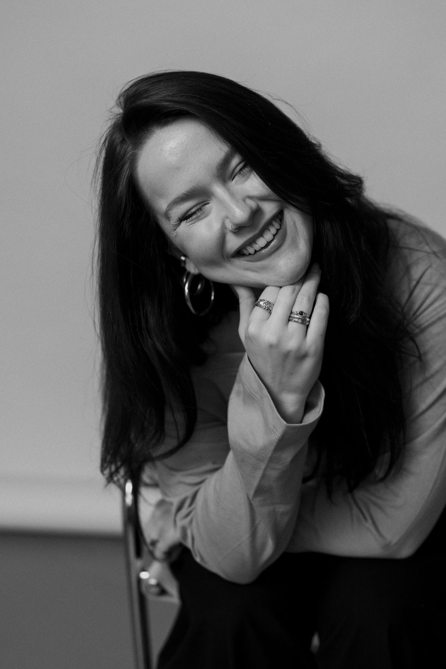 A series of black and white portraits showing dynamic poses and expressions with long dark hair against a gray background.
