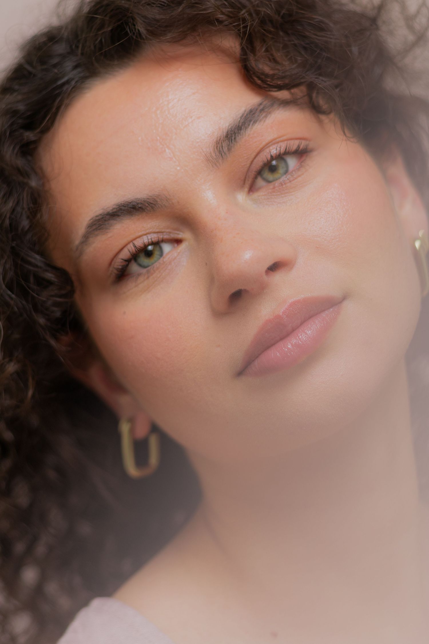 Artistic close-up beauty shots featuring curly hair and soft makeup.
