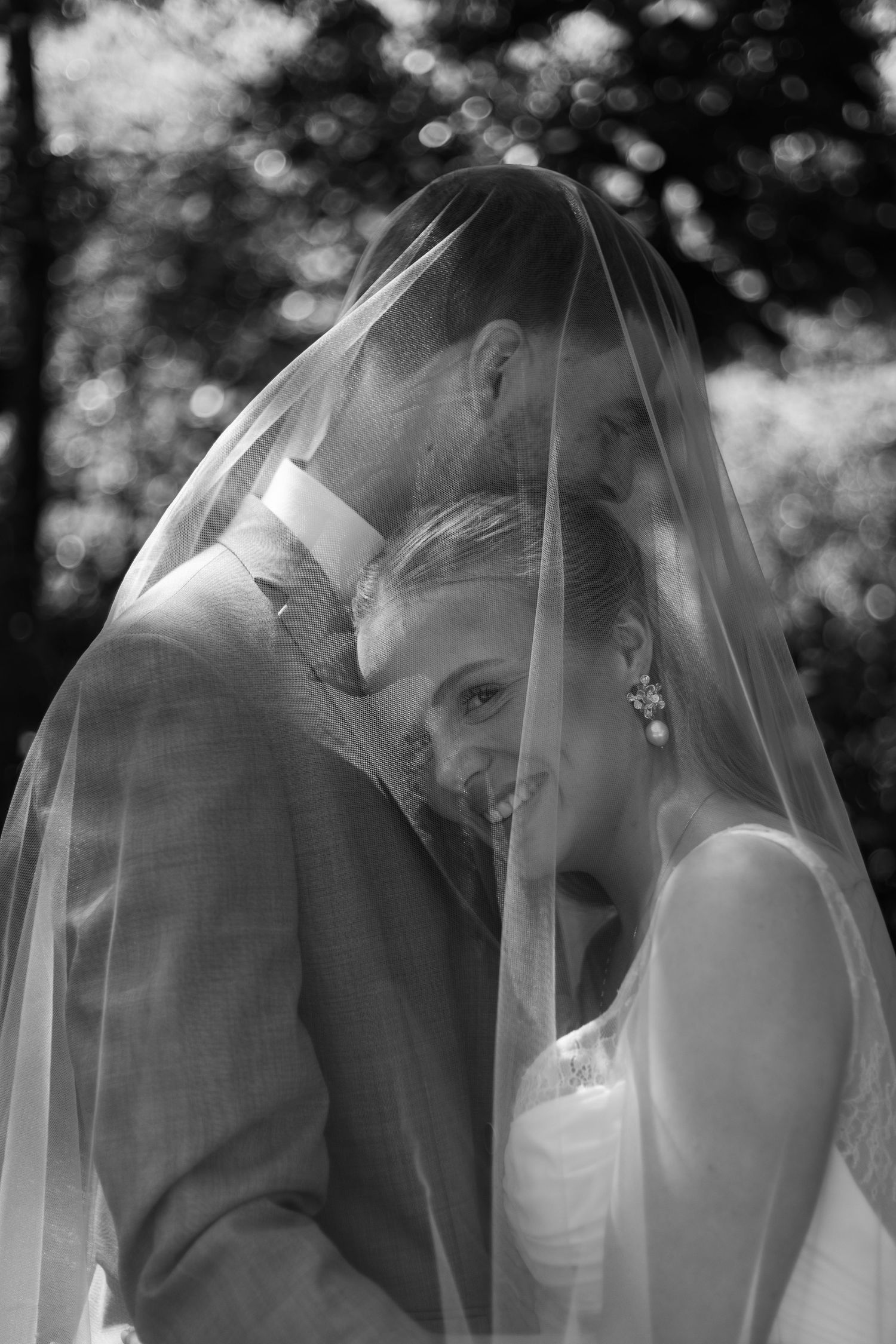 Black and white romantic wedding photo sequence showing a bride and groom sharing tender moments under a veil.