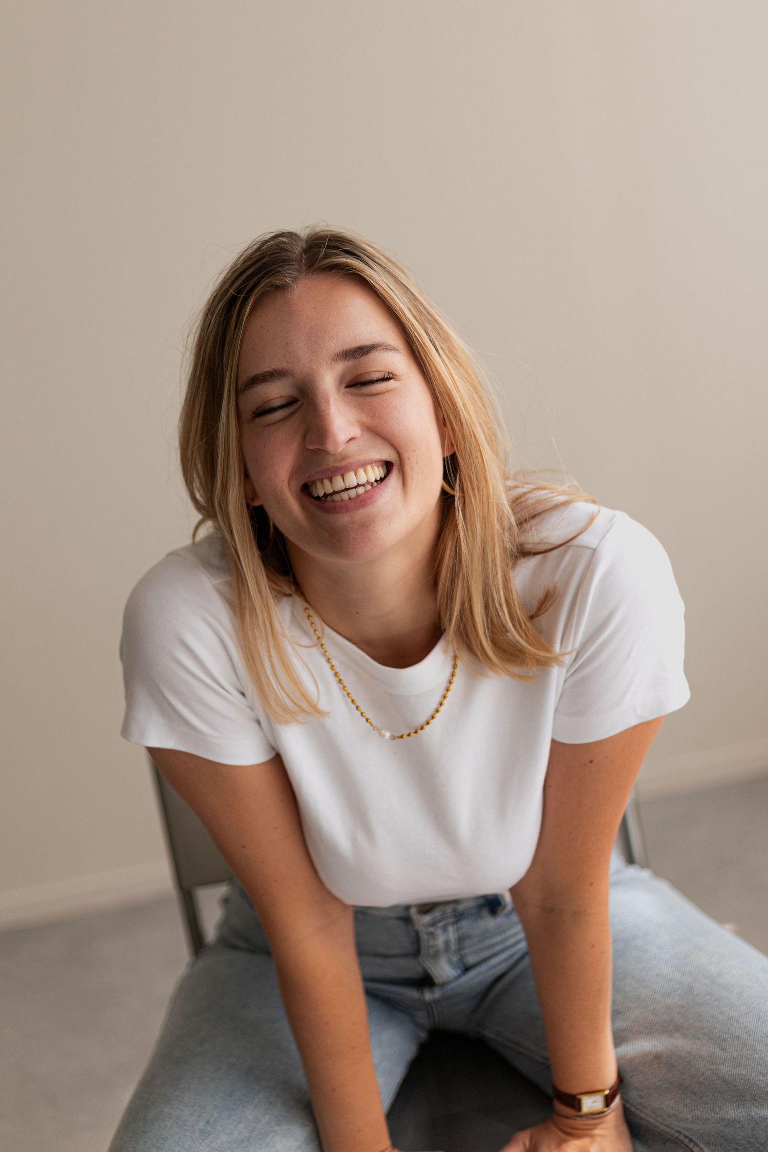 Candid portrait series showing joyful expressions against light studio background.
