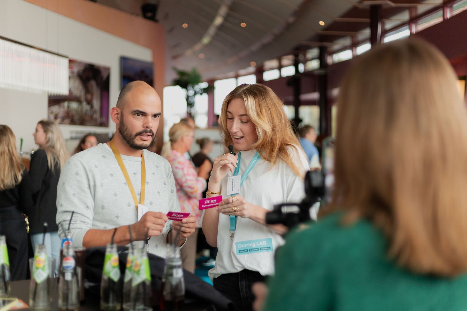 Business professionals networking and socializing at a corporate event with drinks in hand.