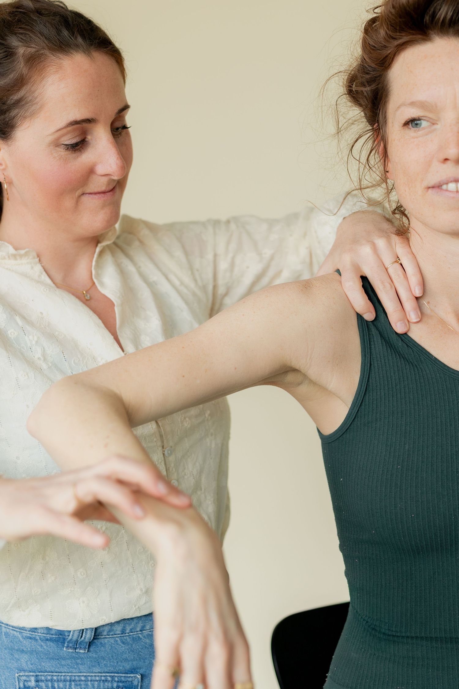 A physical therapist assists a woman with shoulder mobility exercises during a rehabilitation session.
