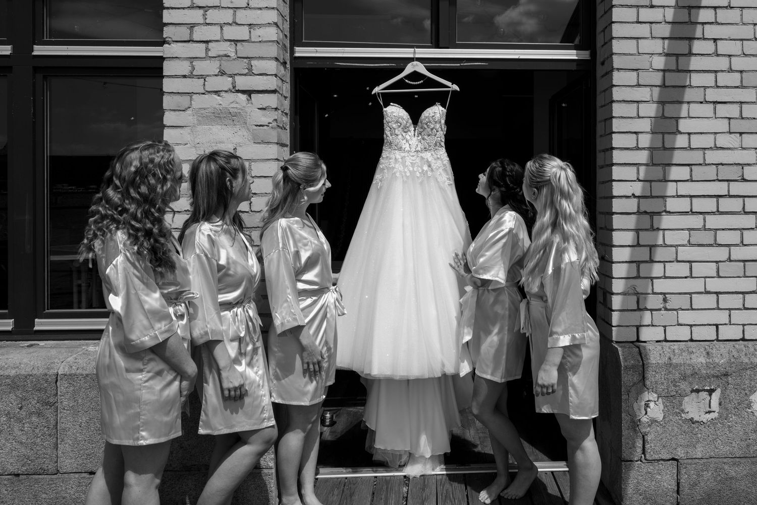 Freie Trauung an der White Spreelounge Berlin, Brautjungfern betrachten gemeinsam das Brautkleid beim Getting Ready