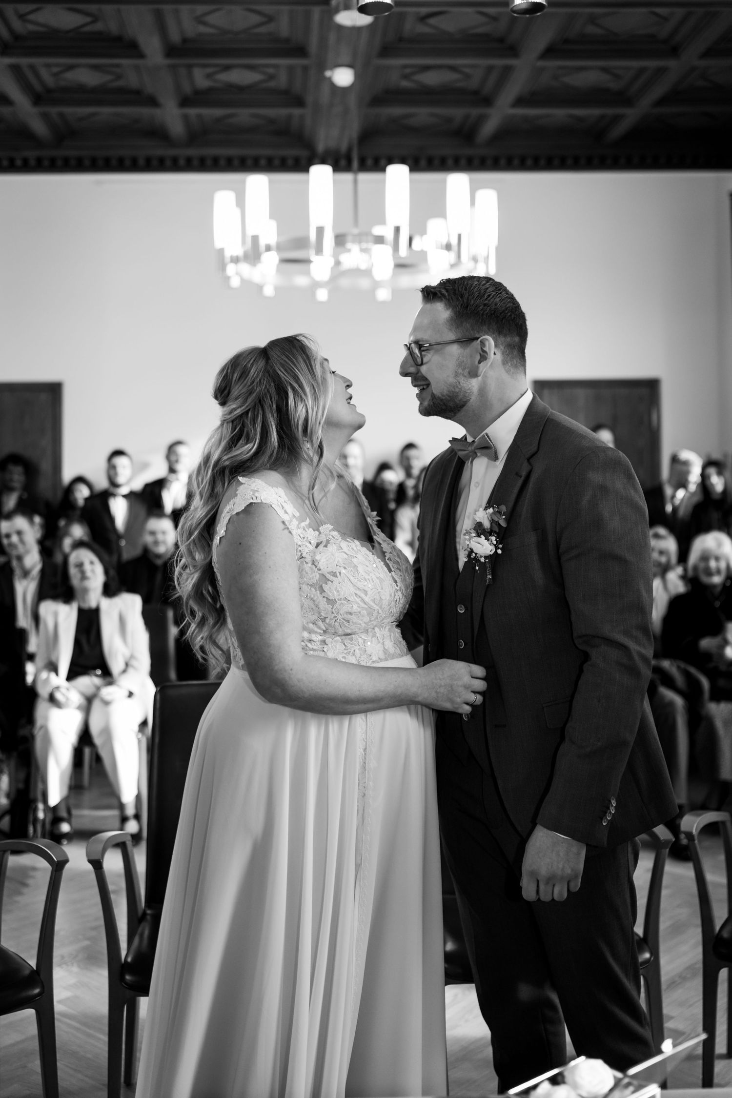 Hochzeit im Standesamt Dortmund, emotionaler Kuss des Brautpaares vor den Gästen in Schwarz Weiß