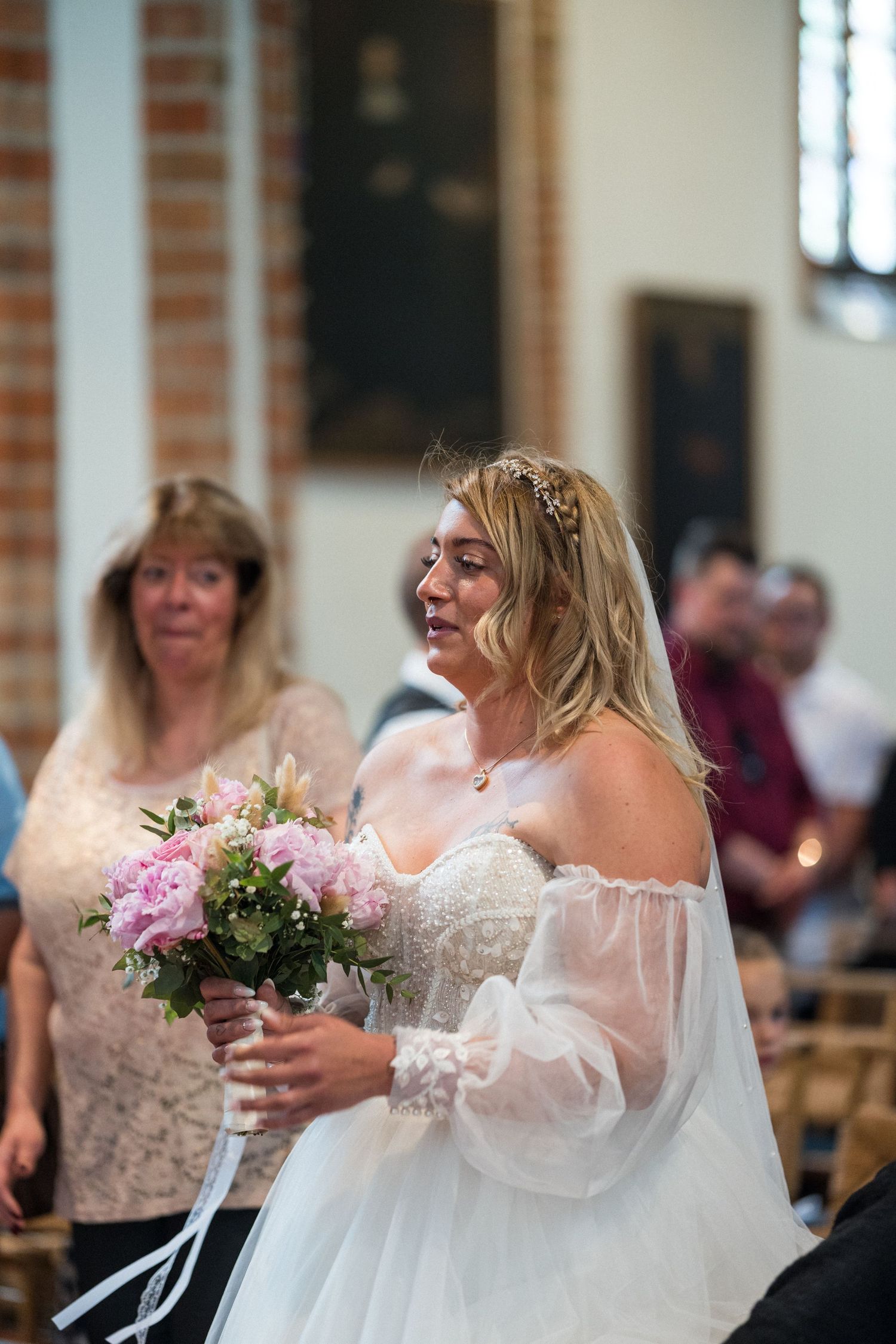 Hochzeit im Spandau, kirchliche Trauung St.-Nikolai-Kirche, Braut kommt lächelnd mit Blumenstrauß nach vorne