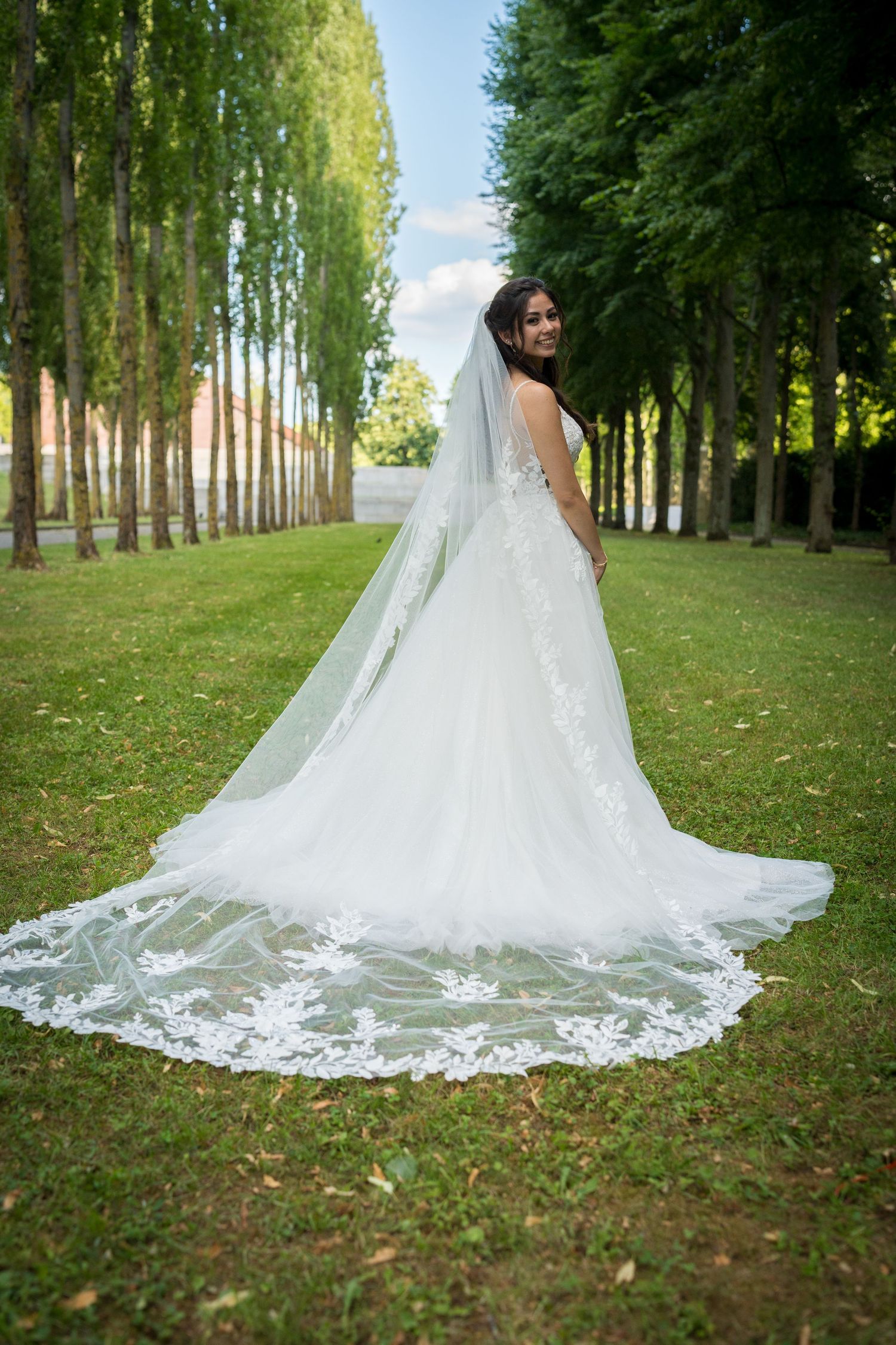 Braut im Hochzeitskleid von hinten mit ausgebreitetem Schleier im Treptower Park