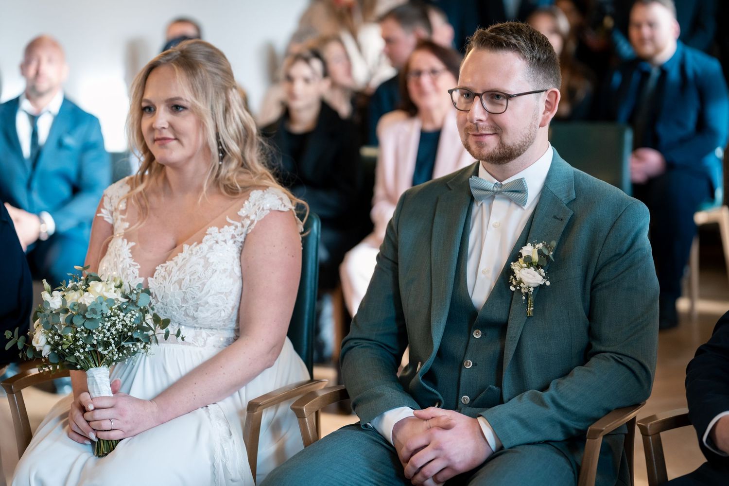 Hochzeit im Standesamt Dortmund, Brautpaar sitzt gemeinsam vor den Gästen im Trausaal